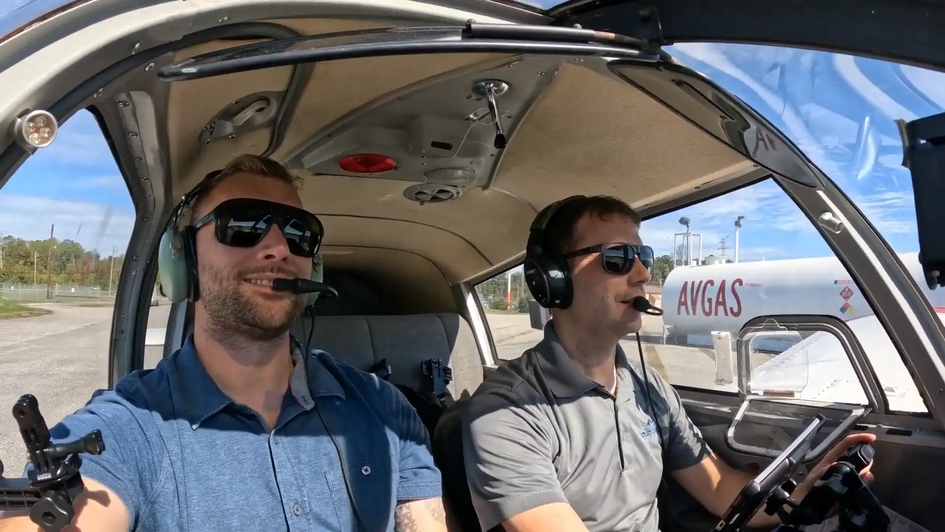 Student pilot and instructor smiling inside the training aircraft before a lesson