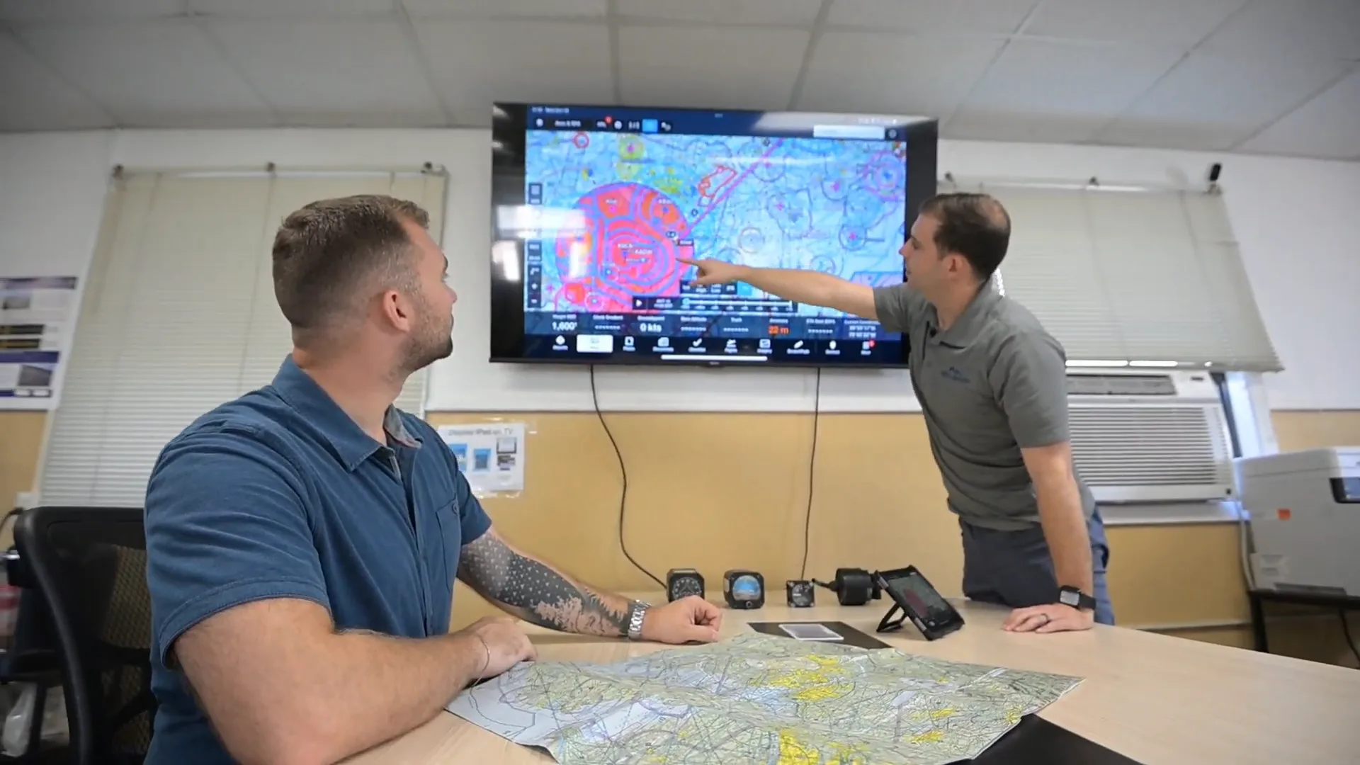 Flight instructor reviewing airspace boundaries and navigation plan with a student pilot