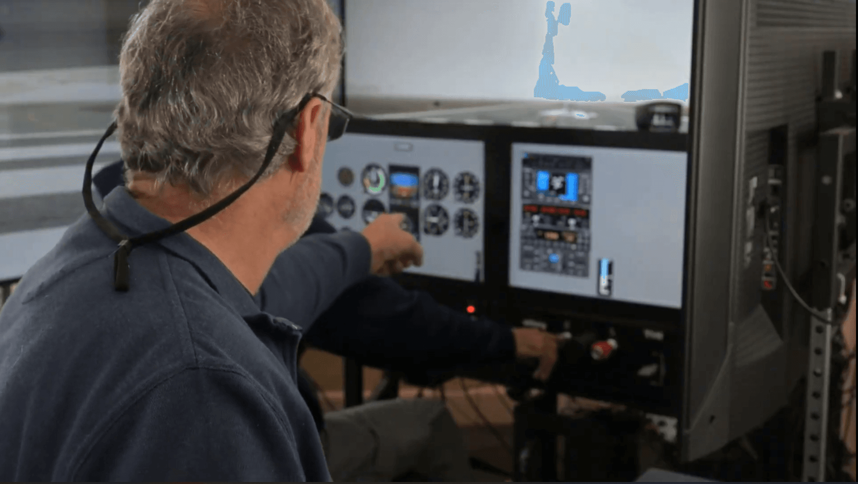 Flight instructor demonstrating avionics and cockpit instruments in an AATD simulator