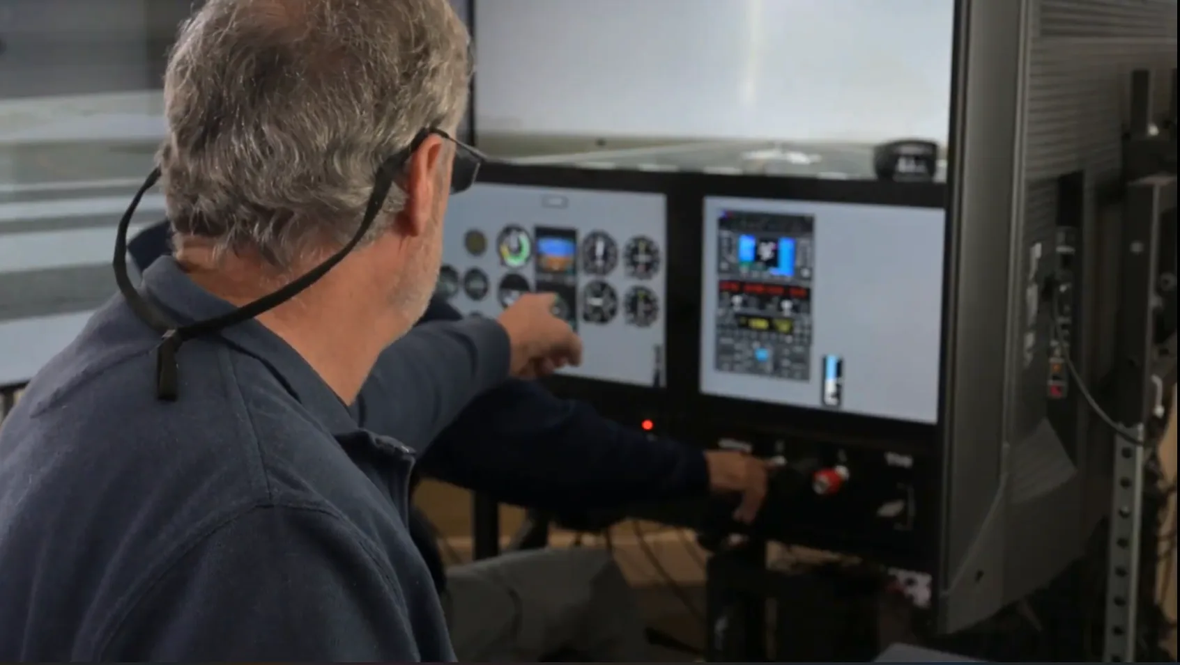 Instructor pointing at the controls inside the SG-2 simulator