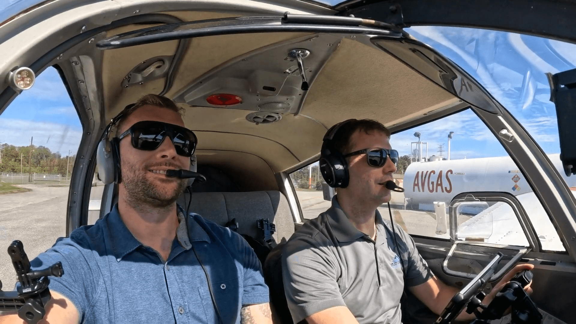 Two confident flight intructors sitting in a cockpit after a successful training flight